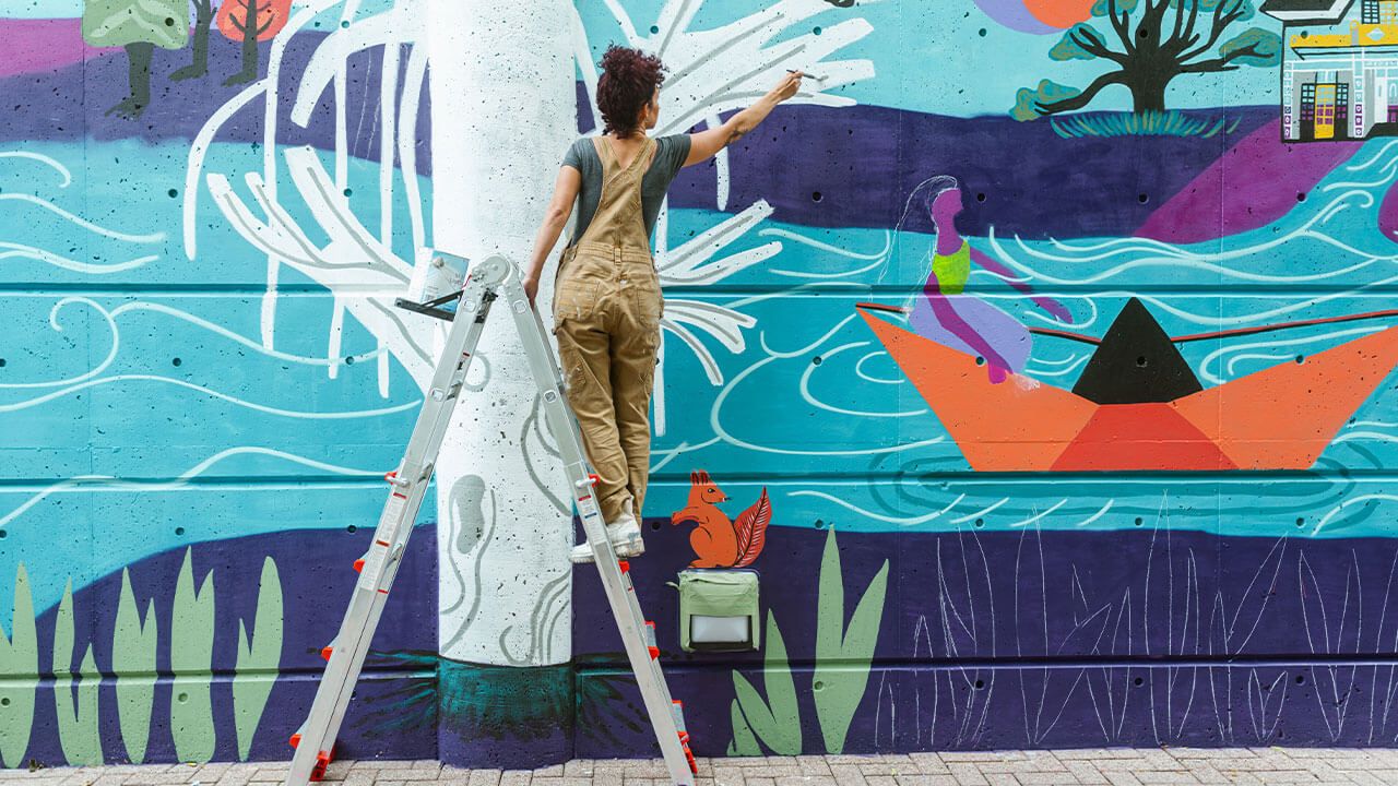 artist painting a mural wall
