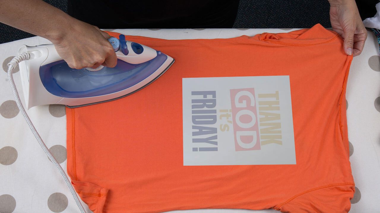 Person ironing heat transfer onto shirt