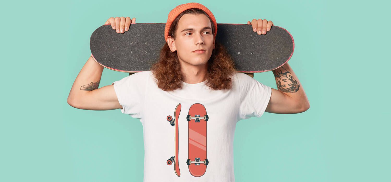 Person with long hair and a beanie holds a skateboard behind their neck, wearing a white T-shirt with skateboard graphics, against a teal background.